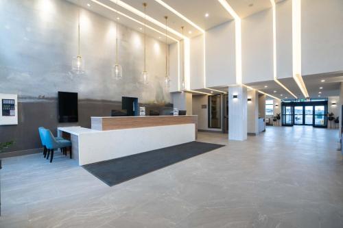 a lobby with a reception desk in a building at Sandman Signature Dartmouth Hotel & Suites in Halifax