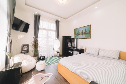 a bedroom with a bed and a tv in it at Darest's Home in Da Lat