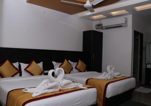 a hotel room with two beds with towels on them at CS Arunachala Residency in Tiruvannāmalai