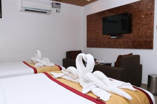 a hotel room with white towels on the beds at CS Arunachala Residency in Tiruvannāmalai