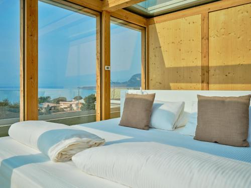 two beds in a room with a large window at Villa Sunny Lake Suites in Bardolino