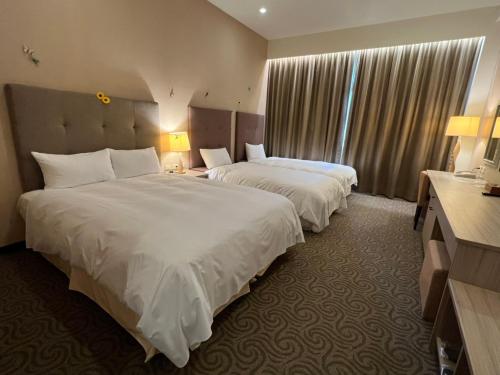 a hotel room with two beds and a window at Jade Garden Hote in Gukeng