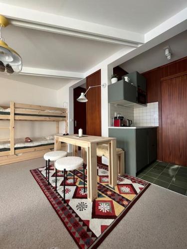 - un salon avec une table et deux tabourets sur un tapis dans l'établissement La Mongie - Studio rénové avec terrasse plein sud, à Bagnères-de-Bigorre