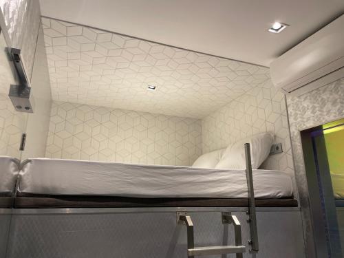 een kleine kamer met een stapelbed bij Diamond Capsule Hotel Amsterdam South in Amstelveen