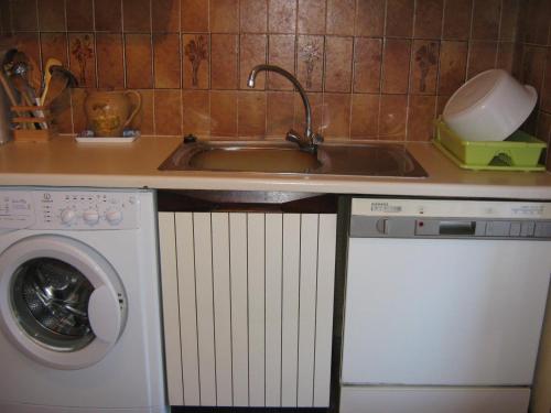 une cuisine avec un évier et une machine à laver dans l'établissement BEAU RIVAGE SAINT RAPHAEL 83700 FRANCE, à Saint-Raphaël