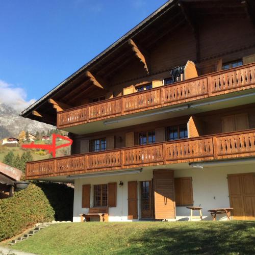 a building with wooden balconies on top of it at Wonderful apartment overlooking the Swiss alps in Chateau-d'Oex