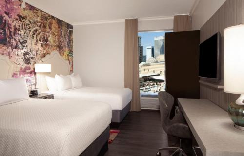 a hotel room with two beds and a desk at Hotel Indigo Atlanta Midtown by IHG in Atlanta