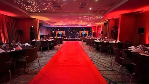 a red carpet in a dining room with tables and chairs at Crowne Plaza Reading in Reading