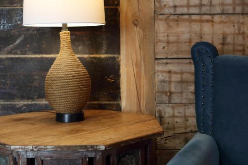 a lamp sitting on a table next to a chair at Frica Ludvika Garden Apartment in Liepāja