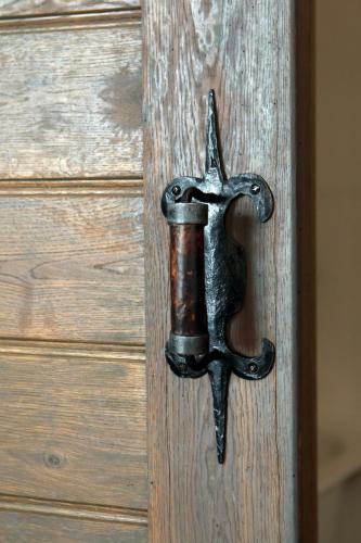 a metal door handle on a wooden door at Frica Ludvika Garden Apartment in Liepāja