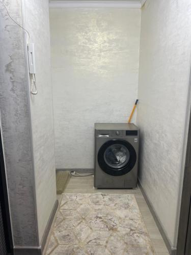 a bathroom with a washing machine in a room at Апартамент 1 комнатный in Taraz