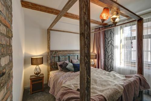 1 dormitorio con cama con dosel y espejo grande en Frica Ludvika Garden Apartment, en Liepāja