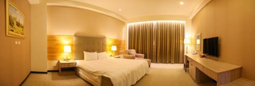a hotel room with a bed and a television at Jade Garden Hote in Gukeng