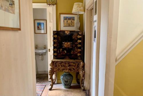 a chair sitting in a hallway with a sink at Fabulous Grade 2 Listed Home in Heart of Stow in Stow on the Wold