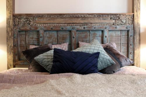a pile of pillows sitting on top of a bed at Frica Ludvika Garden Apartment in Liepāja