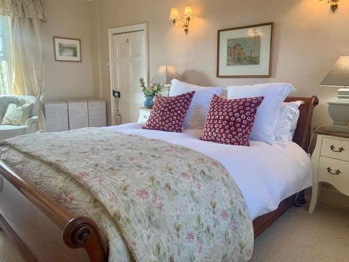 a bedroom with a large bed with pillows on it at Fabulous Grade 2 Listed Home in Heart of Stow in Stow on the Wold