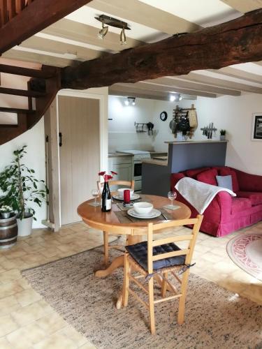 un salon avec une table et un canapé rouge dans l'établissement La Vieille Ferme, à Donnay