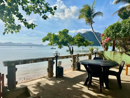 a table and chairs next to the beach at Desert Rose Beach Hotel in El Nido
