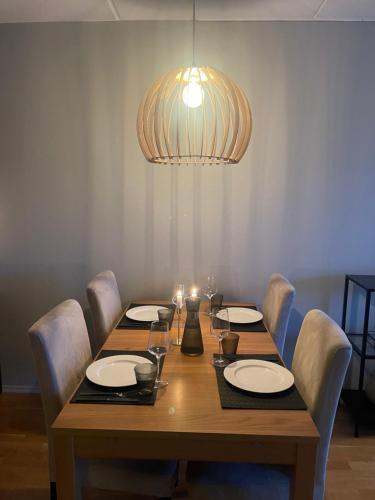 mesa de comedor con sillas y lámpara en Leilighet i Tromsø, en Tromsø