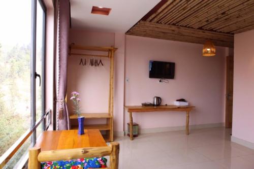 sala de estar con mesa y ventana en Sapa indigo inn, en Sa Pa