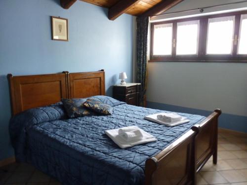 1 dormitorio con 1 cama con 2 toallas en Agriturismo Viticcio, en La Morra