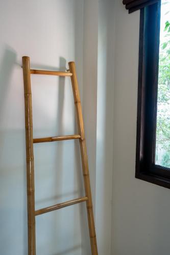 a wooden ladder leaning against a wall next to a window at Wind Beach Resort in Koh Tao