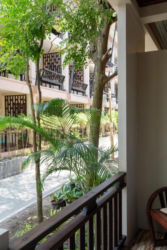 a balcony with a view of a courtyard with benches at Wind Beach Resort in Koh Tao