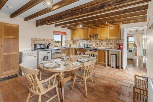 a kitchen with a table and chairs in a room at Harvest Cottage and Holly Barn in Yarm