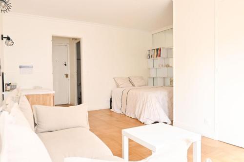 Cette chambre blanche dispose d'un lit et d'un canapé. dans l'établissement Appartement à Paris, à Paris