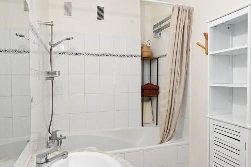 une salle de bain blanche avec une baignoire et un lavabo dans l'établissement Appartement à Paris, à Paris