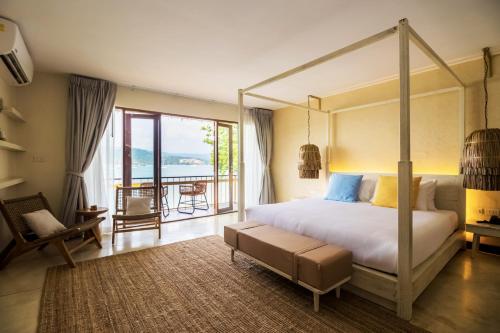 a bedroom with a canopy bed and a balcony at Sea Sun Bed & Beyond in Koh Samui 