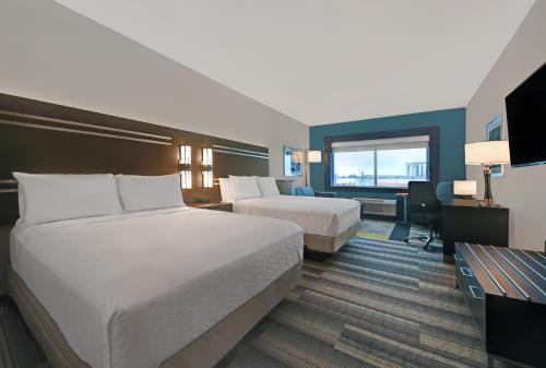 a hotel room with two beds and a desk at Holiday Inn Express & Suites Memorial – CityCentre by IHG in Houston