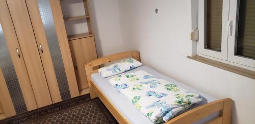 małe łóżko w pokoju z oknem w obiekcie Ferienwohnung, Monteurwohnung Steger w mieście Frammersbach