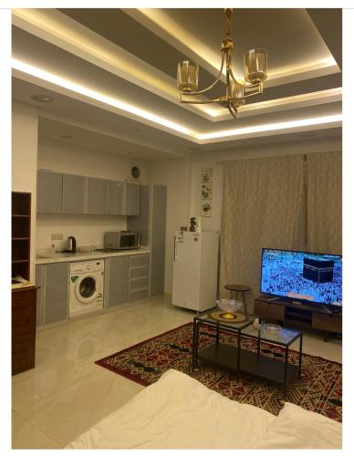 a kitchen with a living room with a television and a table at استديو حي النزهه in Jeddah