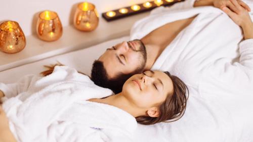 a man and woman laying in bed with christmas lights at Intercontinental Real Guatemala by IHG in Guatemala