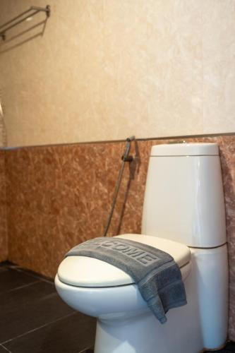 a bathroom with a toilet with a blue towel on it at Wind Beach Resort in Koh Tao