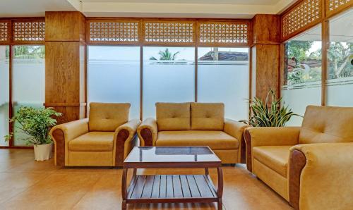 a living room with two couches and a coffee table at Treebo Golden Terminal, Kochi Airport in Cochin