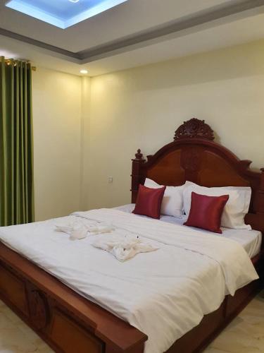 a bedroom with a large white bed with red pillows at Eng resident guesthouse in Phnom Penh