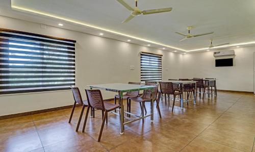 a dining room with tables and chairs and windows at Treebo Golden Terminal, Kochi Airport in Cochin