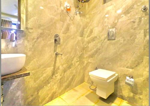 y baño con aseo blanco y lavamanos. en Empire inn Suites Hotel Near Delhi Airport, en Nueva Delhi