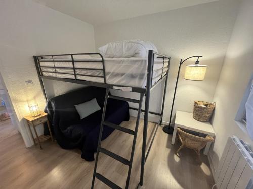 une chambre avec un lit superposé et une chaise dans l'établissement Chez Alix et Jo Superbe T3 au bord de l’Océan, à Lacanau