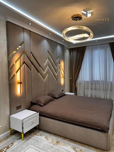 een slaapkamer met een groot bed en een kroonluchter bij Premium 3- roomed apartment near REGISTAN in Samarkand
