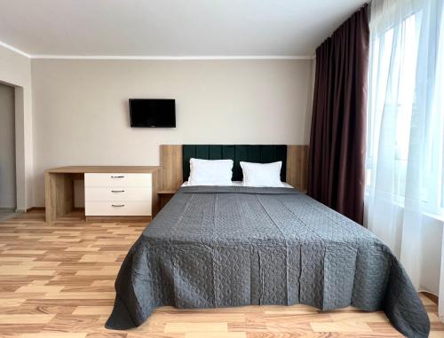 a bedroom with a bed and a tv on the wall at Sineva Del Sol Apartments in Sveti Vlas