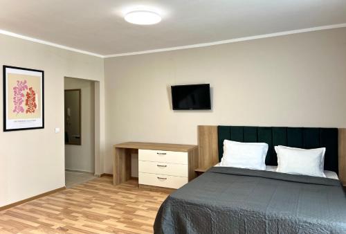 a bedroom with a bed and a desk and a television at Sineva Del Sol Apartments in Sveti Vlas
