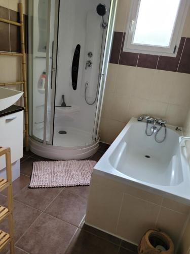 La salle de bains est pourvue d'une douche et d'un lavabo blanc. dans l'établissement Années 80, enquête et jeux hors du temps, à Saint-Romain-le-Preux