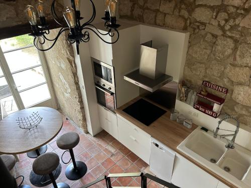 uma cozinha com uma mesa e uma bancada em Un Petit Château em Lauzun