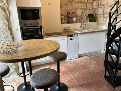 uma cozinha com uma mesa e cadeiras e um lavatório em Un Petit Château em Lauzun