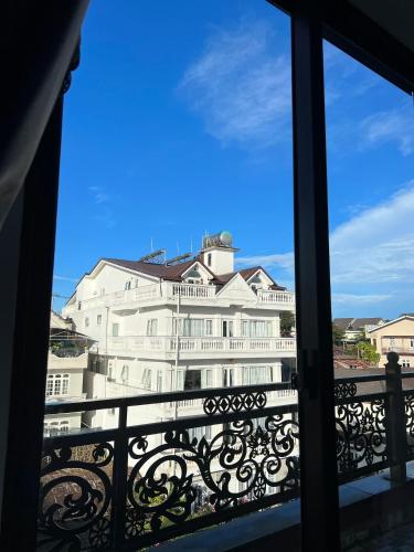 a view of a large white building from a balcony at Darest's Home in Da Lat
