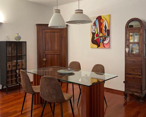 a dining room with a glass table and chairs at Casa Matilde in Ferrara