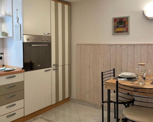 a kitchen with a table and a refrigerator at Casa Matilde in Ferrara